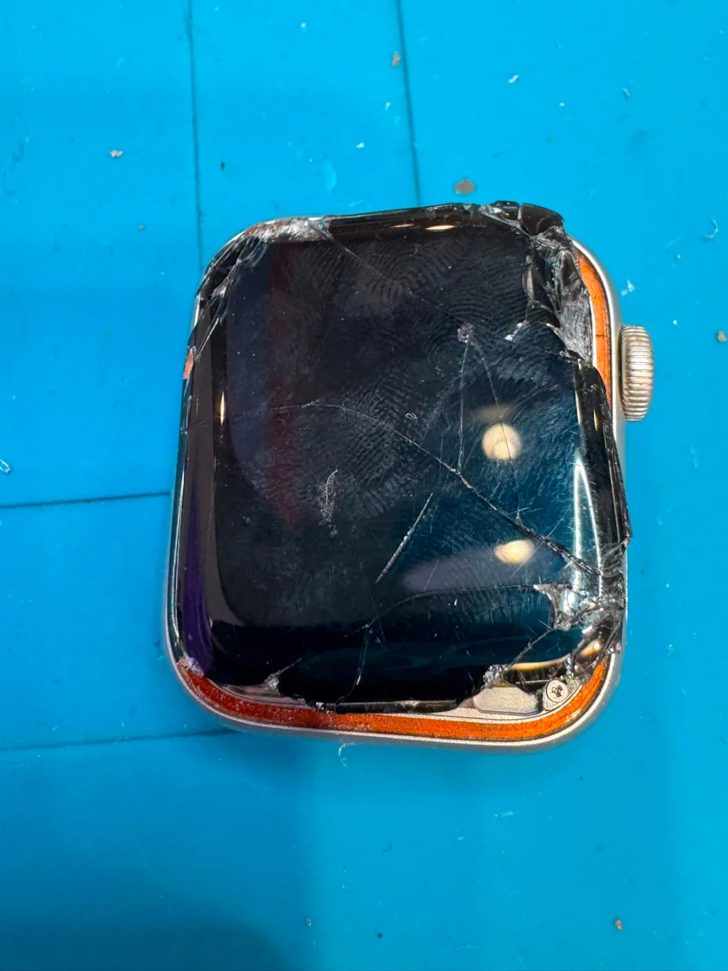 Apple Watch with a badly cracked and shattered screen on a repair mat, before screen replacement in Adelaide